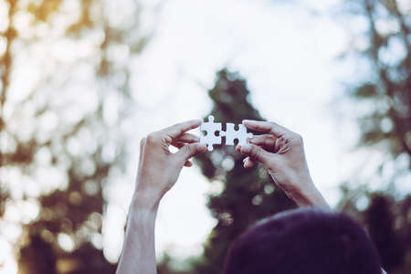 Hands people connect couple puzzle piece together with sun light,Business success and strategy concept,Close upの写真素材