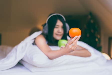 Beautiful asian woman hands holding fresh orange with eating for breakfast healthy,Selective focusの写真素材