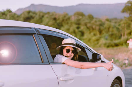 Hipster young asian woman wearing hat and sunglasses sitting in her car at outdoor,Relaxing...