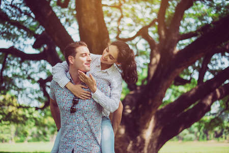 Couple in love girlfriend riding on back of boyfriend at park,Romantic and enjoying in moment of happiness time,Happy and smilingの写真素材