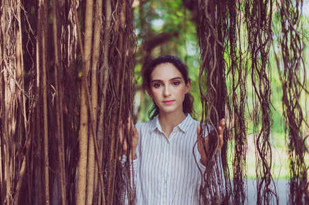 Confidence woman standing and looking to you near tree,Happy and smiling,Positive thinking,Relaxing timeの写真素材