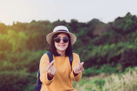 Happy asian woman standing and showing mini heart shape at sunset, Free time, Positive thinking