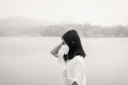 Asian woman using mask protect PM 2.5 because pollution at nature,Young female got nose...
