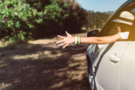 Happy asian woman showing hand while sitting in new car on road,Relax and free time,Positive...