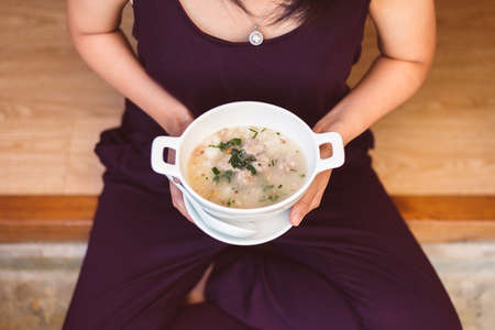 Woman hands holding and eating mush or boiled rice,Healthy breakfast in the morning,Enjoys of...