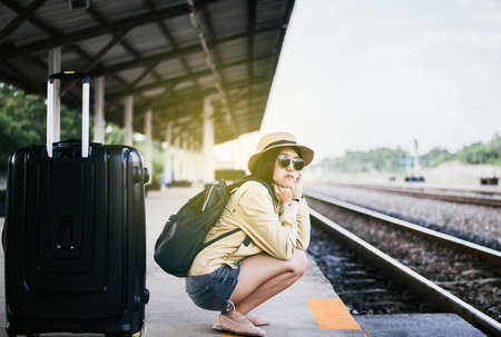 Hipster asian woman tourist waiting train at train station,Travel and vacation conceptの写真素材