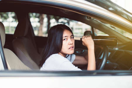 Drunk asian woman drinking alcohol while driving car on road,Women drive her car with a bottle of...
