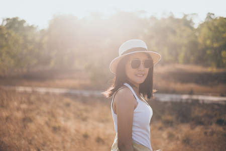 Portrait of beautiful asian woman happy and smiling at nature on during sunset,Relax and free timeの写真素材