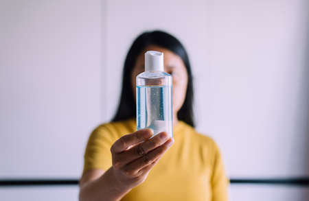 Woman hands holding sanitizer gel in pump bottle for hand hygiene coronavirus protection