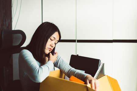 Woman holding box and equipment from work,Unemployment job conceptの写真素材
