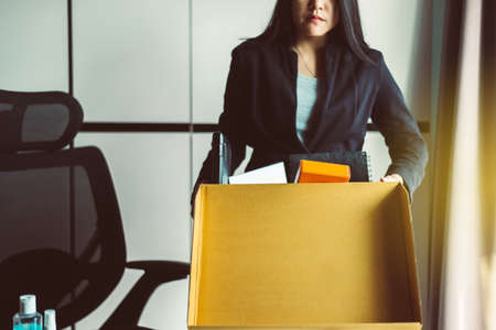 Woman holding box and equipment from work,Unemployment job conceptの写真素材