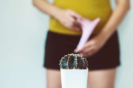 Blurred woman standing on white background with cactus and suffering from hemorrhoids,Need to pee