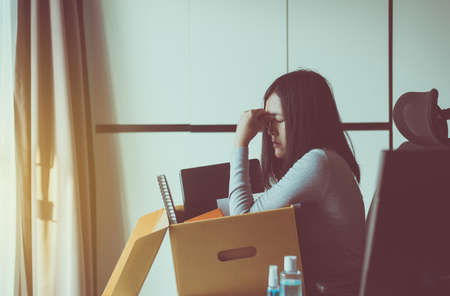 Woman holding box and equipment from work,Unemployment job conceptの写真素材