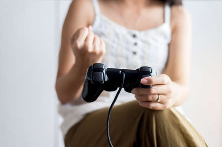 Close up of hands woman playing video games at home,Women holding joystick