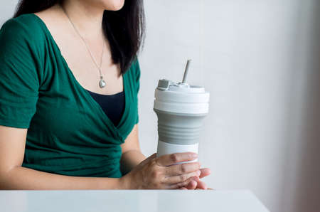 Hand woman holding reusable coffee mug,Healthy green,Zero waste,Environmental friendly,Conscious lifestyle conceptの写真素材
