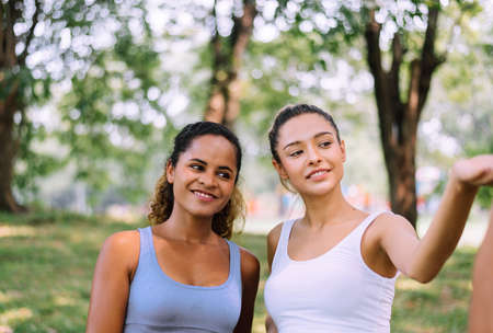 Couple of young sporty woman standing together at public park in the morning,Happy and smiling,Relaxing timeの写真素材