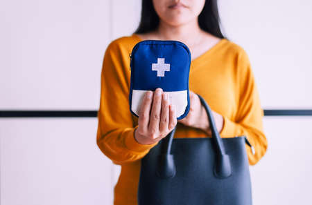 Hands woman holding a medicine first aid kit bag putting into handbag,Healthy and lifestyle conceptの写真素材