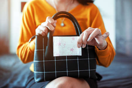 Woman hand putting sanitary napkin in handbag,White menstrual pad,Menses