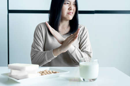 Woman having a stomach pain with a glass of milk at home,Allergy dairy intolerant,Lactose intolerance conceptの写真素材
