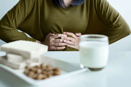 Allergy dairy intolerant,Lactose intolerance concept,Asian woman having a stomach pain with a glass...