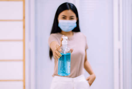 Woman holding sanitizer hand gel in pump bottle for hygiene coronavirus protectionの写真素材