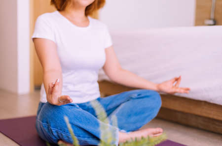 Woman sitting practicing doing yoga meditation in bedroom,Workout exercise after waking up in...