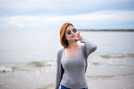 Happy traveller asian woman wearing sunglasses at the beach,Enjoying and relaxing timeの写真素材