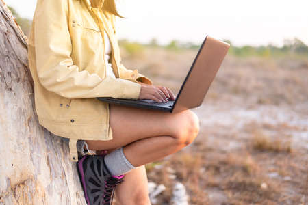 Solo traveller asian woman tourist using internet with laptop computer at forest,Travel and vacation conceptの写真素材