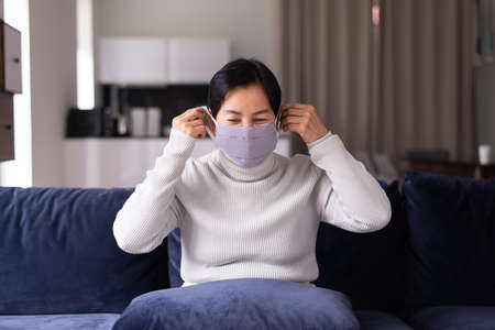 Mature asian woman using masks protect coronavirus or covid-19 at home,Coronavirus protection mask