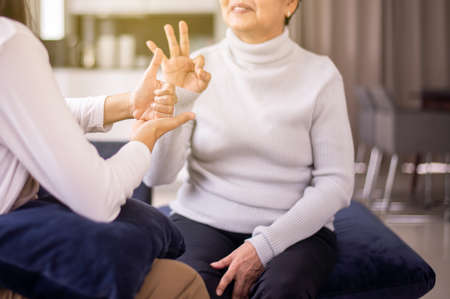 Sign language specialist talking with mature patient deaf hearing and showing hands gestureの写真素材