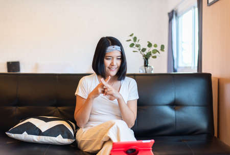 Happy asian woman communicating via sign hands language on video call to a deaf person