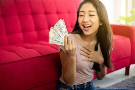 Happy asian woman hands holding US dollar bills,Rich peopleの写真素材