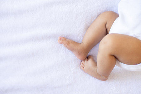 Close up of little feet newborn baby lying on a comfortable bed at home