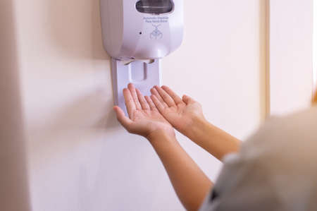 Patient woman using automatic alcohol dispenser sanitation for cleaning hands in hospital,Protection spread of  virusの写真素材