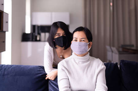 Senior asian woman and daughter wearing masks