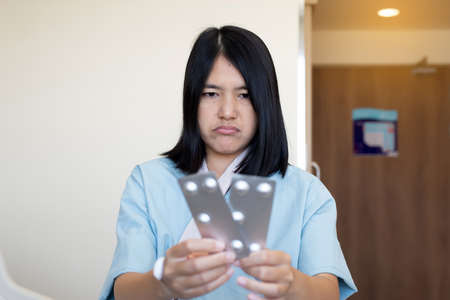 Patient women hands holding pills pack or capsules at hospitalの写真素材
