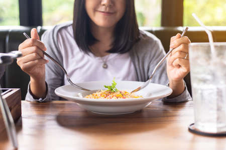 Happy asian woman enjoy eating with delicious food in restaurantの写真素材
