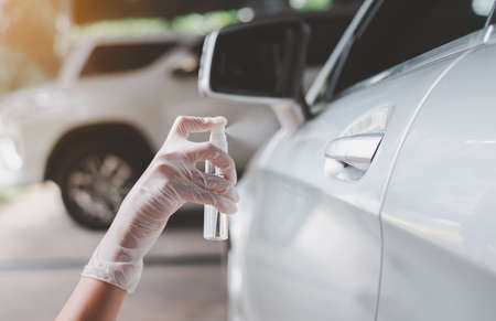 Woman using hand sanitizer gel before driving a car,Preventive measures against coronavirus,Covid-19 pandemicの写真素材