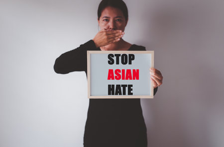 Asian woman showing text stop asian hate,Racism against asian people campaign,Stop asian hate conceptの写真素材