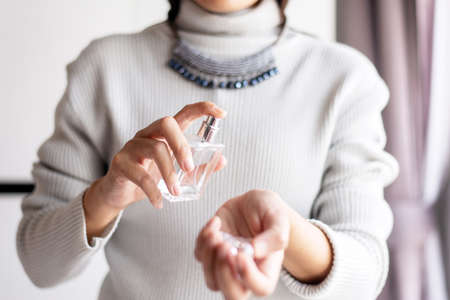 woman hands spraying favorite perfume at home,Applying perfume is the simplest of mattersの写真素材