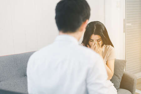 Patient woman crying with professional psychologist,Therapist conducting a consultation and counseling at hospitalの写真素材