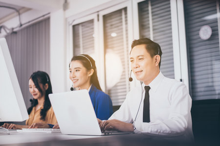 Call center asian team worker together at office,Smiling employees woman operator working with...