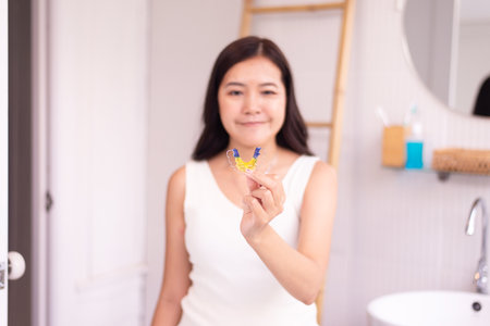 Woman holding braces teeth or silicone trainer,Orthodontic,Dental health concept,Decayed toothの写真素材