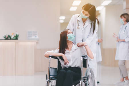 Doctor talking with woman patient and hands holding together,Follow up treatment at hospitalの写真素材