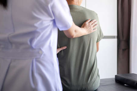 Physiotherapist woman doing treatment to man patient in clinic,Physical therapy conceptの写真素材