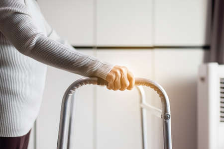 Senior woman hands holding walker trying to walk at home,Physical therapy conceptの写真素材