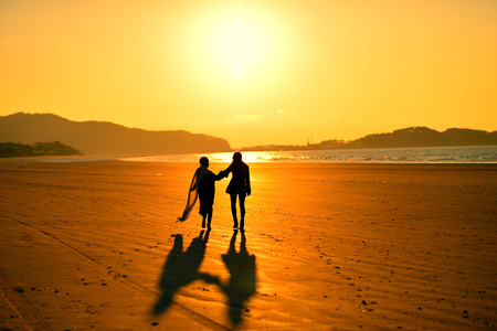 silhouette couple, two friendly couples in the beach at sunsetの写真素材