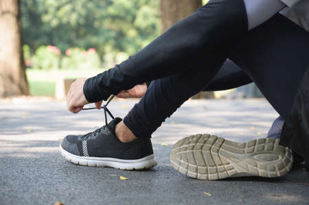 Athlete male hands tying shoelace on running shoes