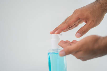 Close-up hand pushing plastic bottle pump with alcohol hand gel. Coronavirus or covid 19 concept.の写真素材
