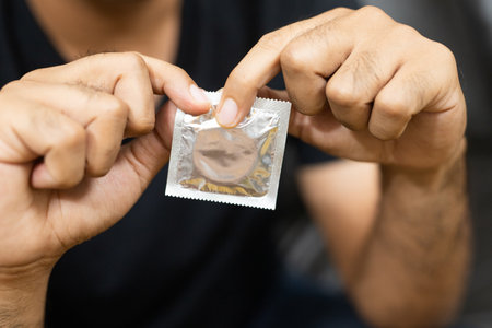 Close up Male hand holding Condom. Safe sex concept.
